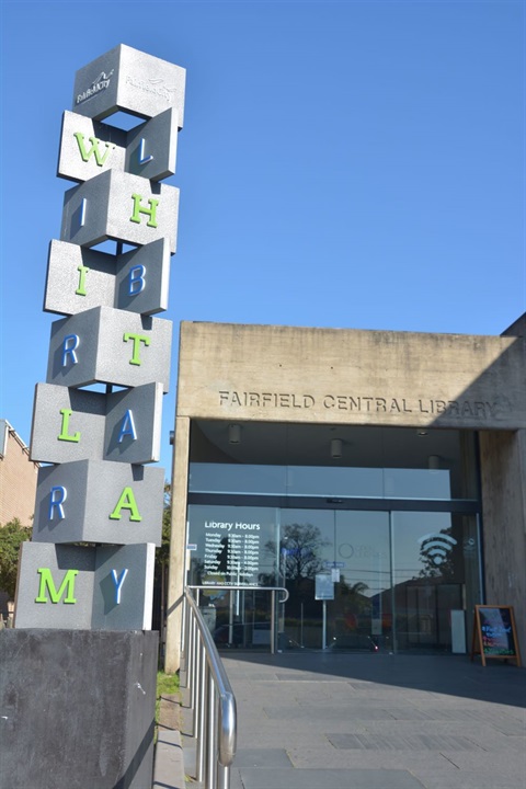 The front entrance of library with a statue out front