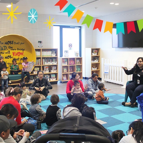 Families gathered together in the children's area of Fairfield Library for storytime