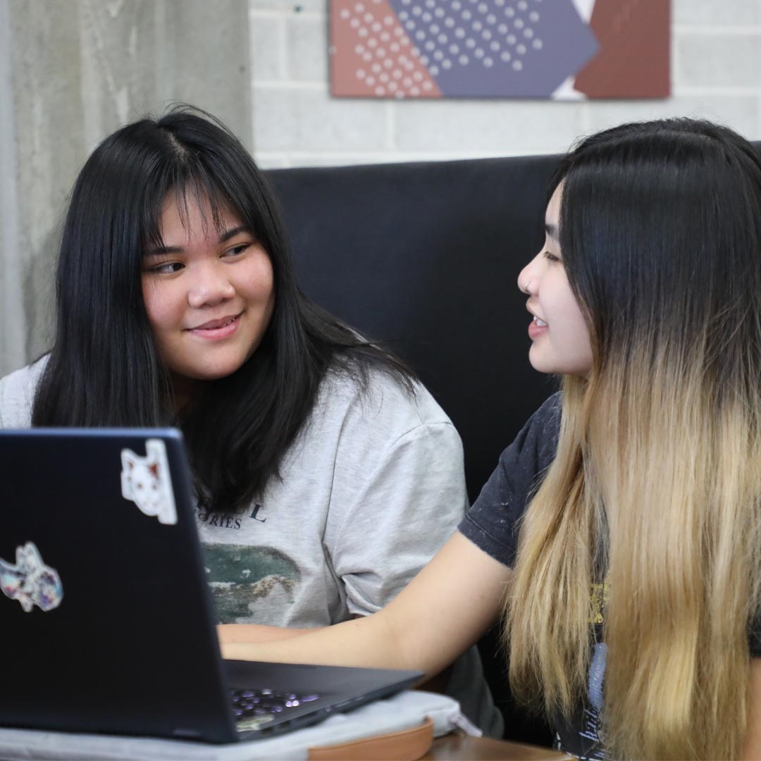 Two young women smiling at each other in The Workary