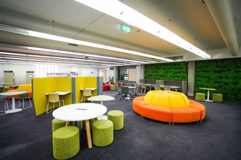 Youth area with bright coloured furniture, study desks, lounges and green walls