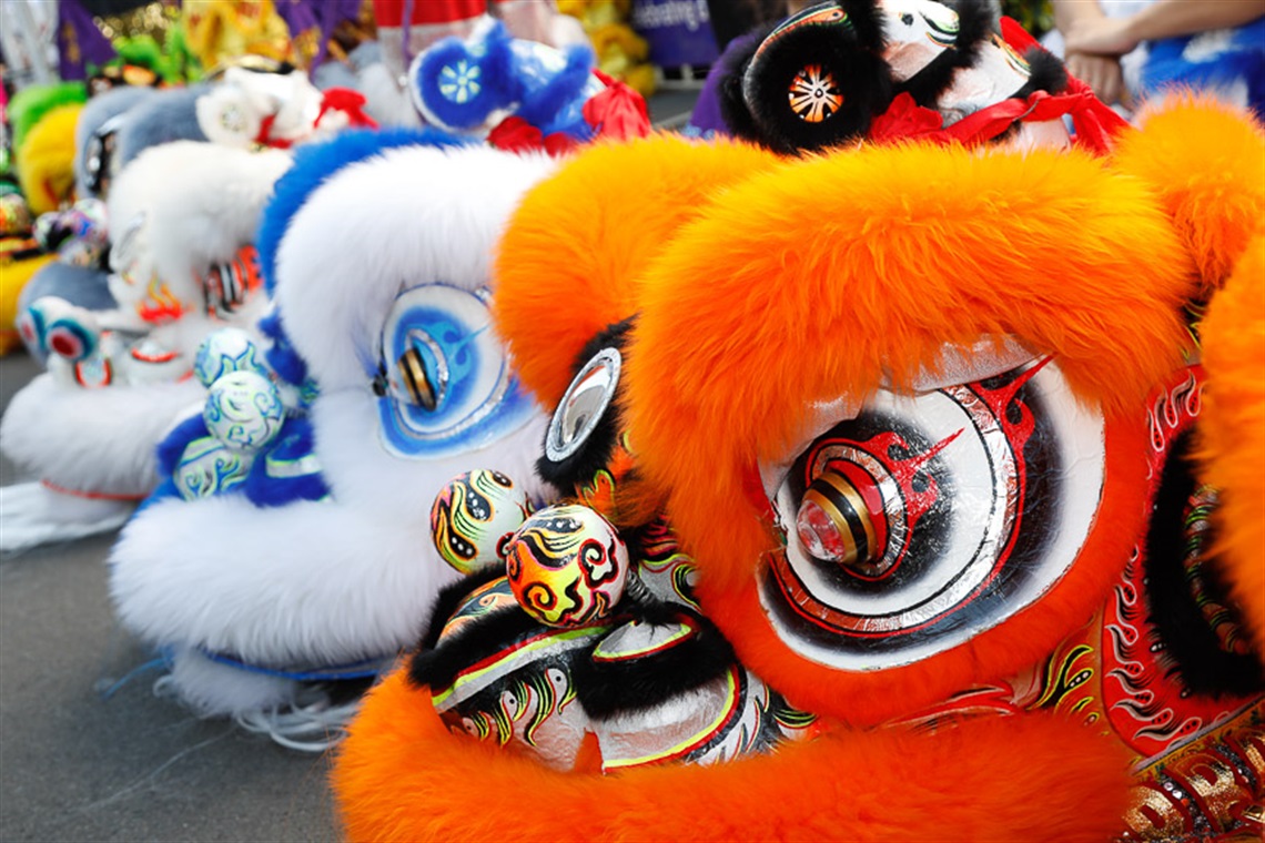 Heads of colourful lion dancing puppets lying on the ground