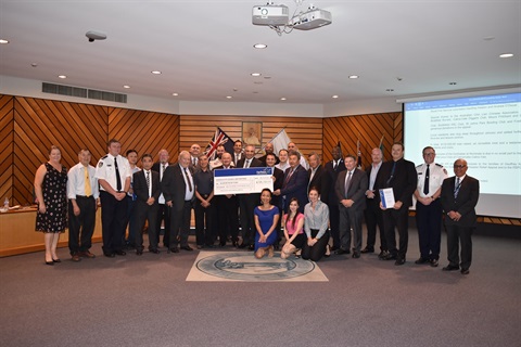 Mayor Frank Carbone and the Councillors smiling and posing while presenting the representatives from Horsley Rural Fire Service, The Salvation Army and RSPCA NSW with novelty cheque