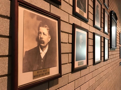 Framed portrait of Mayor Baglee hanging on the wall next to other framed portraits of past mayors