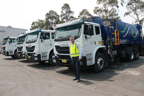 Mayor Frank Carbone smiling and posing with Fairfield City garbage collection trucks