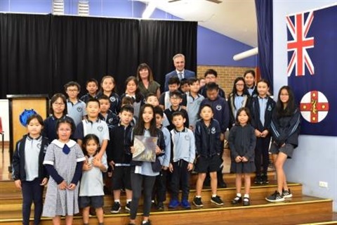 Mayor Frank Carbone smiling and posing with young students from Canley Vale Public School