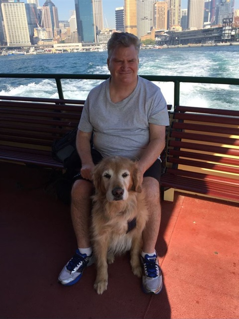Australia Day ambassador for 2022 Mr Nicholas Gleeson pictured on a boat with his guide dog