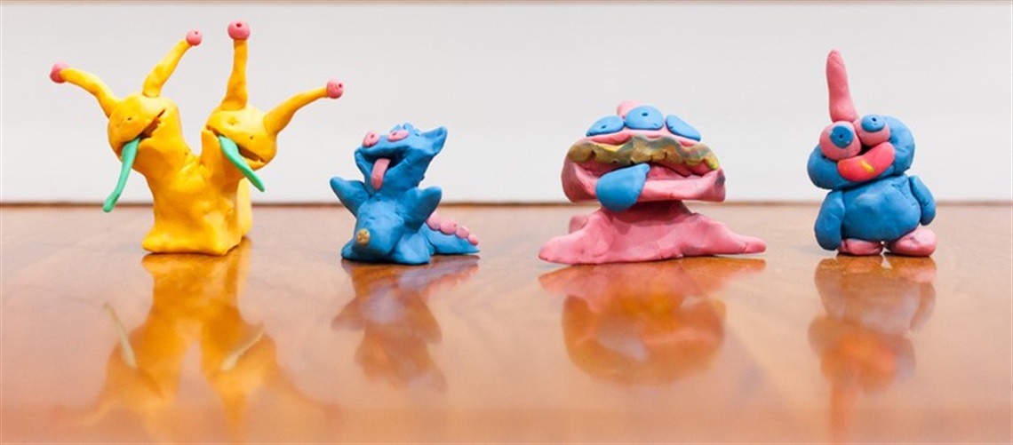 Four sculptures of monsters made out of different coloured clay