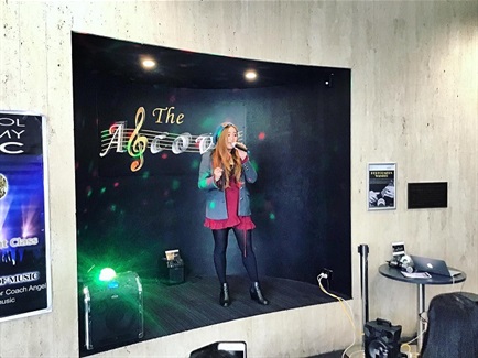 Young girl singing into a microphone at the Alcove in Whitlam Library