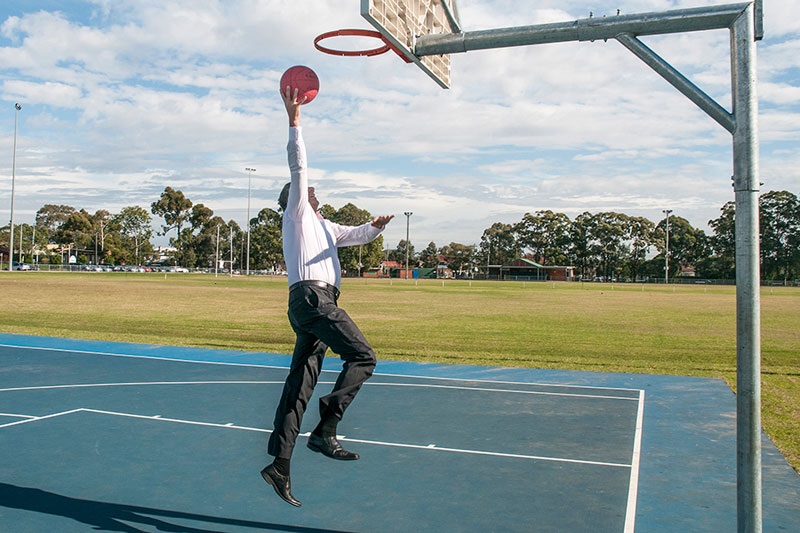 Mayor Frank Carbone shooting a basketball into a hoop 