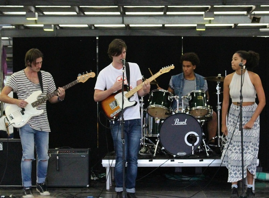 Youth band playing instruments and singing on stage