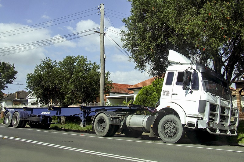 Large truck parked in front of houses within residential area 