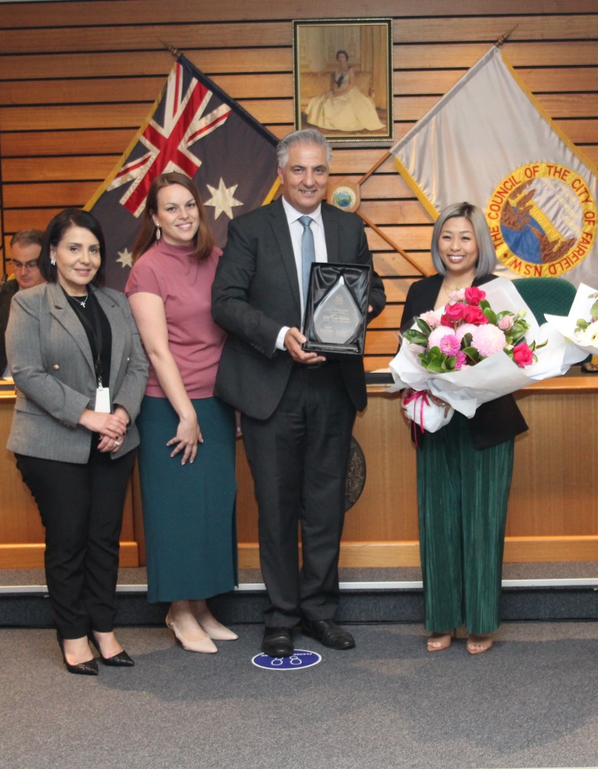 Kim Tran with Women's Day Award standing with the Mayor holding her award.