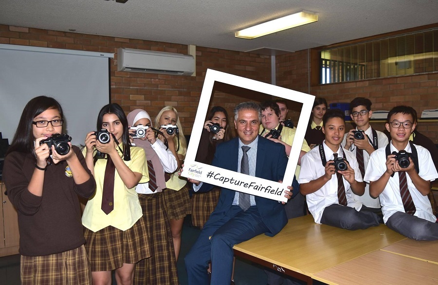 Mayor Frank Carbone and group of Fairvale High School students smiling and posing with cameras and a photo frame prop captioned '#CaptureFairfield'