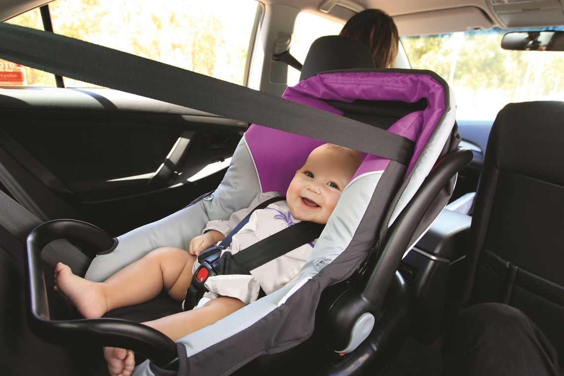 Smiling baby in child safe car seat
