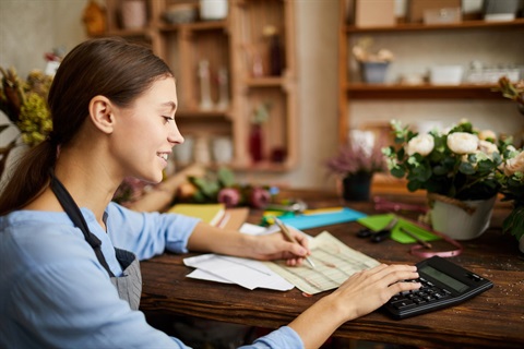 Business woman calculating her finances with a calculator