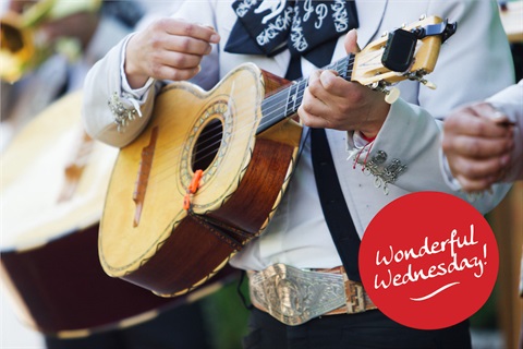 Close up of man playing a ukulele in a mariachi band