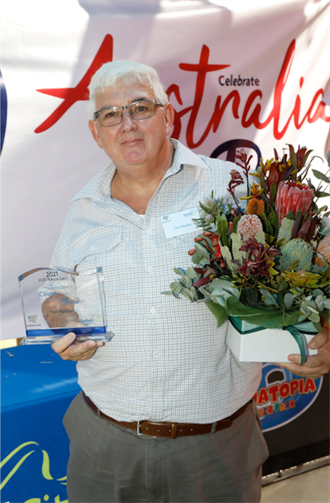 Tom Murphy holding 2021 Fairfield City Citizen of the Year award and bouquet of flowers